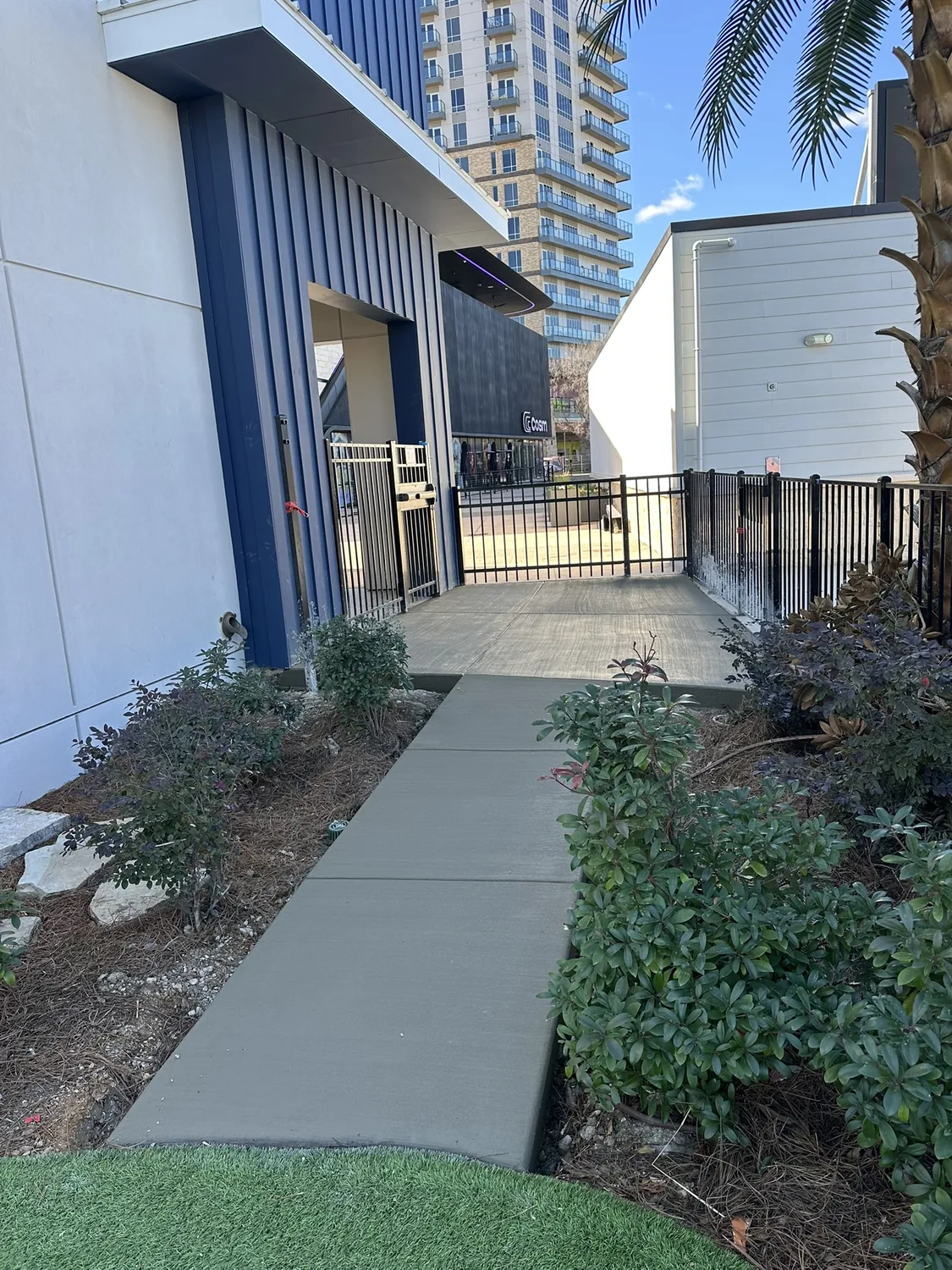 New commercial concrete sidewalk running alongside a building by Lucky's Concrete